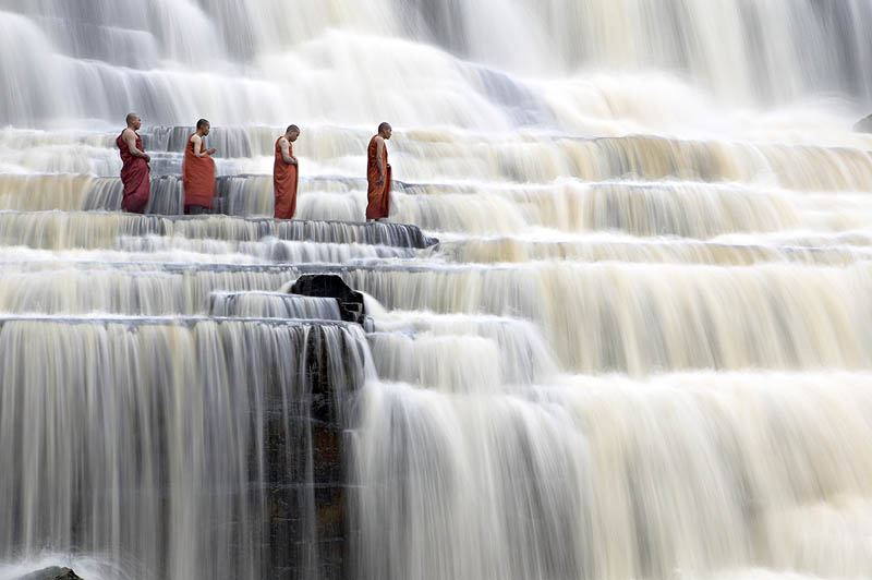 Buddhist monks chant at Pongour Falls, the largest waterfall in Dalat, Vietnam.